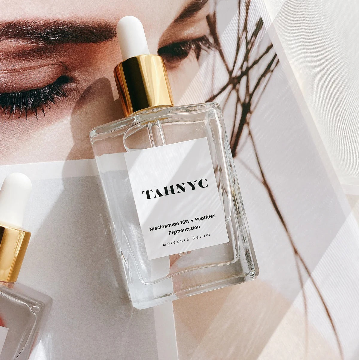 TAHNYC Niacinamide 15% + Peptides Serum flatlay over model image with natural lighting – The Pharmacy Lab