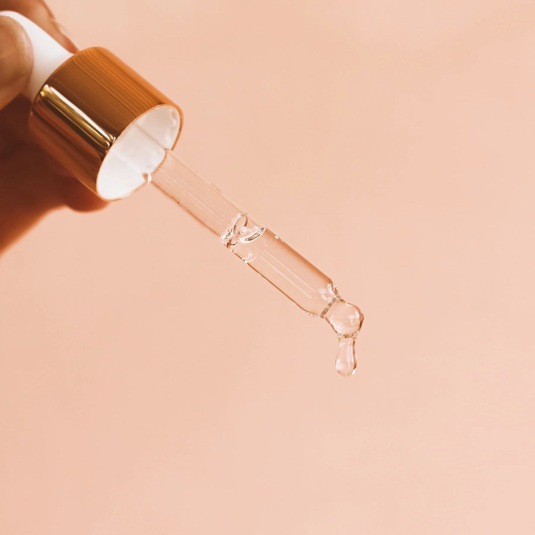 TAHNYC Niacinamide 15% + Peptides Serum dropper releasing liquid on blush backdrop – The Pharmacy Lab