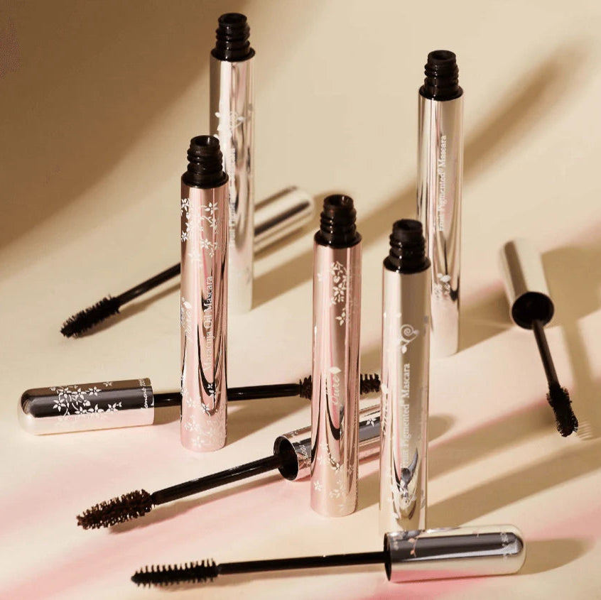 Set of mascara tubes with visible brand names on a light background