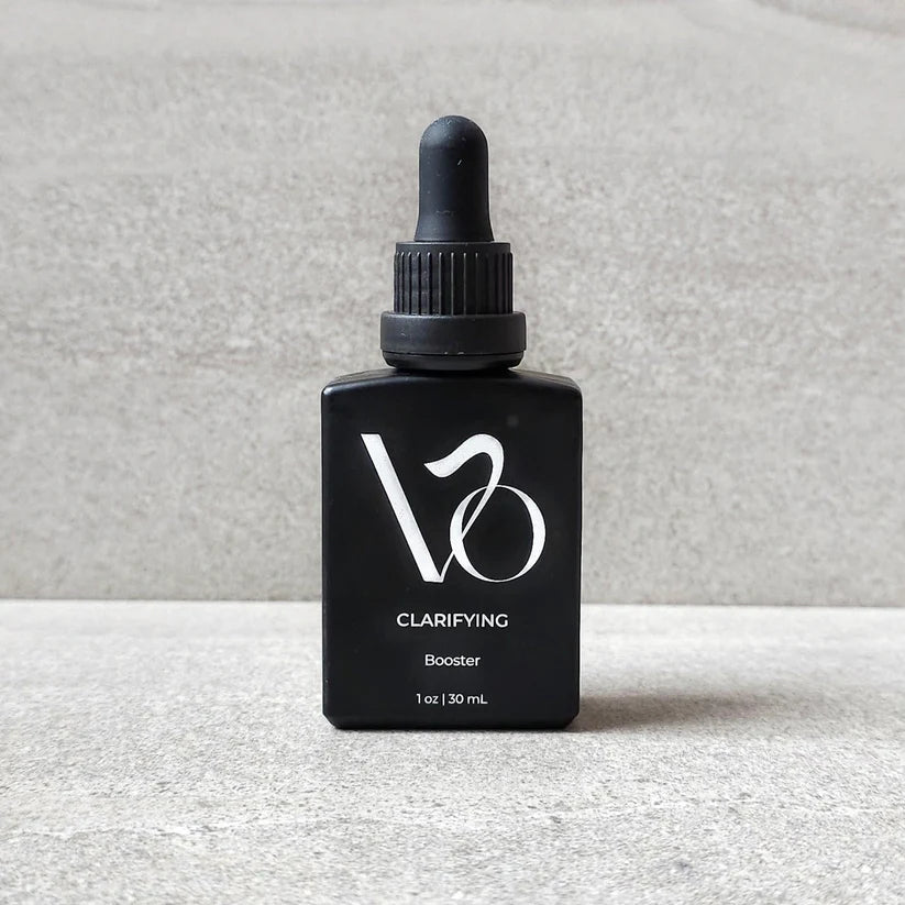 Black bottle with dropper labeled 'V2' on a gray background