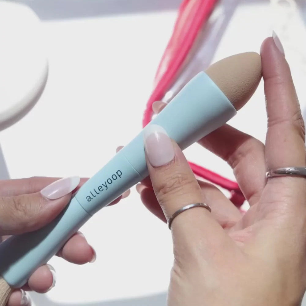 Hand holding a makeup product with 'alleypo' branding against a blurred background