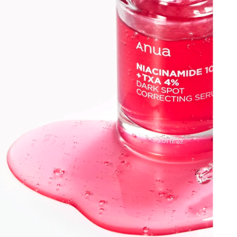 Anua niacinamide serum bottle with pink liquid on a white background