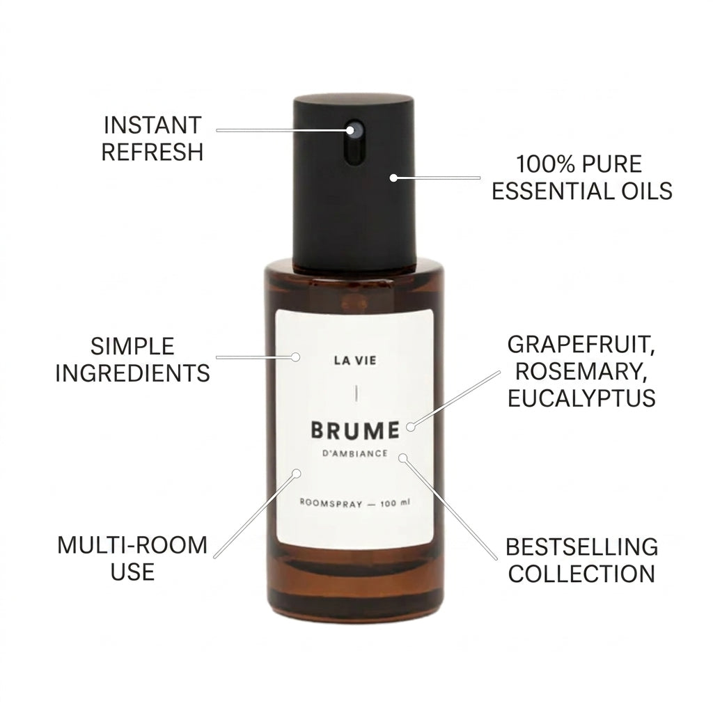 A brown glass room spray bottle labeled LA VIE BRUME D'AMBiance, shown with black text callouts around it reading features like instant refresh, 100% pure essential oils, simple ingredients, grapefruit/rosemary/eucalyptus, multi-room use, and bestselling collection.