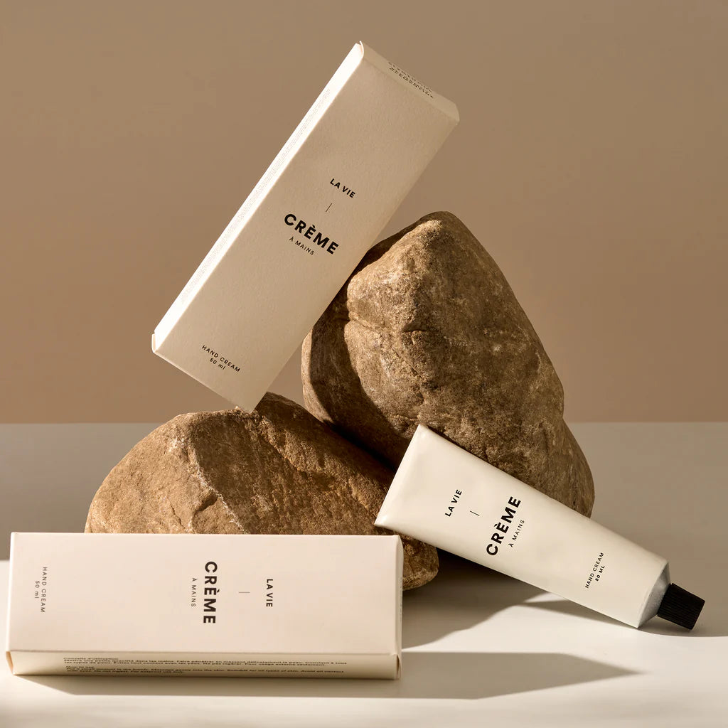 La Vie Crème skincare products on rocks with a neutral background