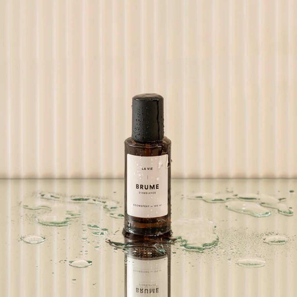 Bottle of Brume on a reflective surface with a neutral background