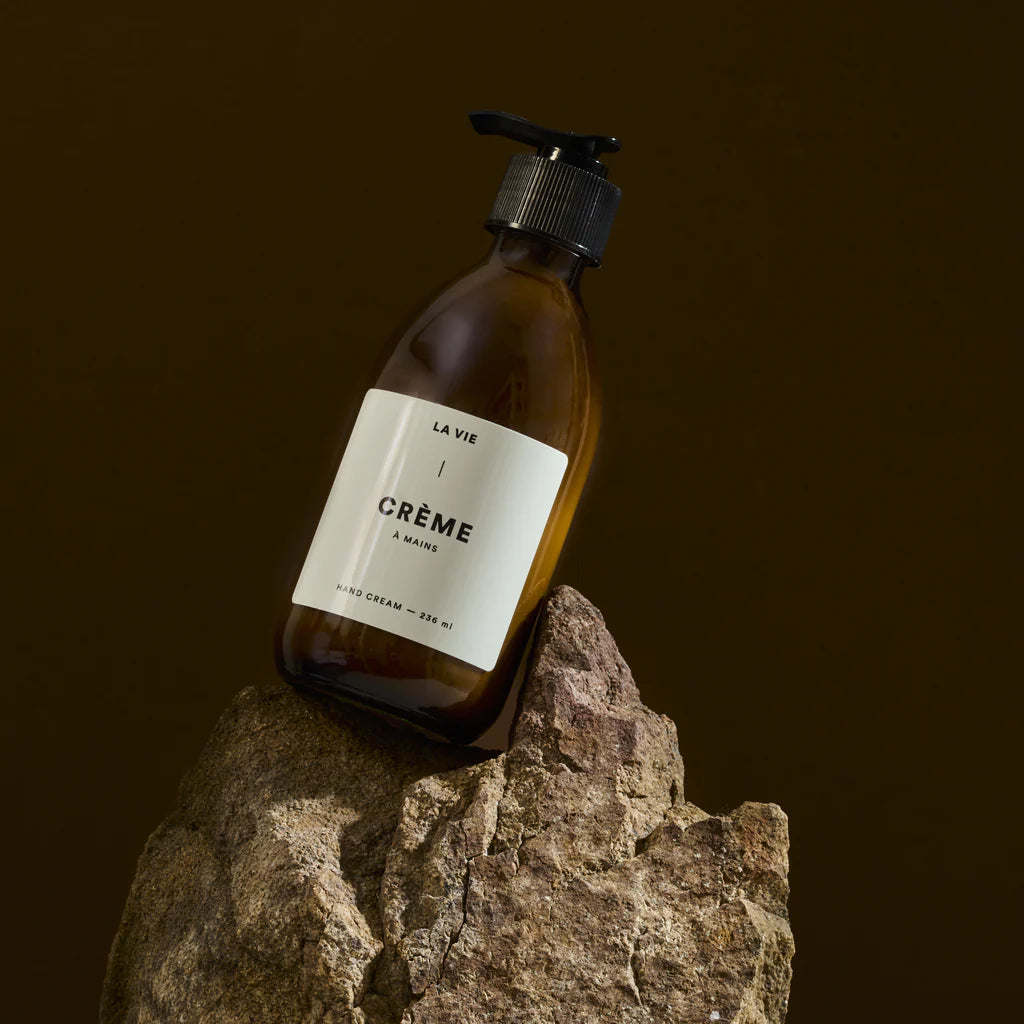 Bottle of 'La Vie Crème' on a rock with a dark background