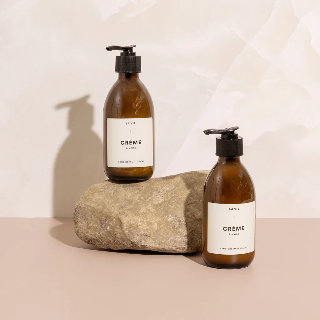 Two bottles of 'La Vie Crème' on a neutral background