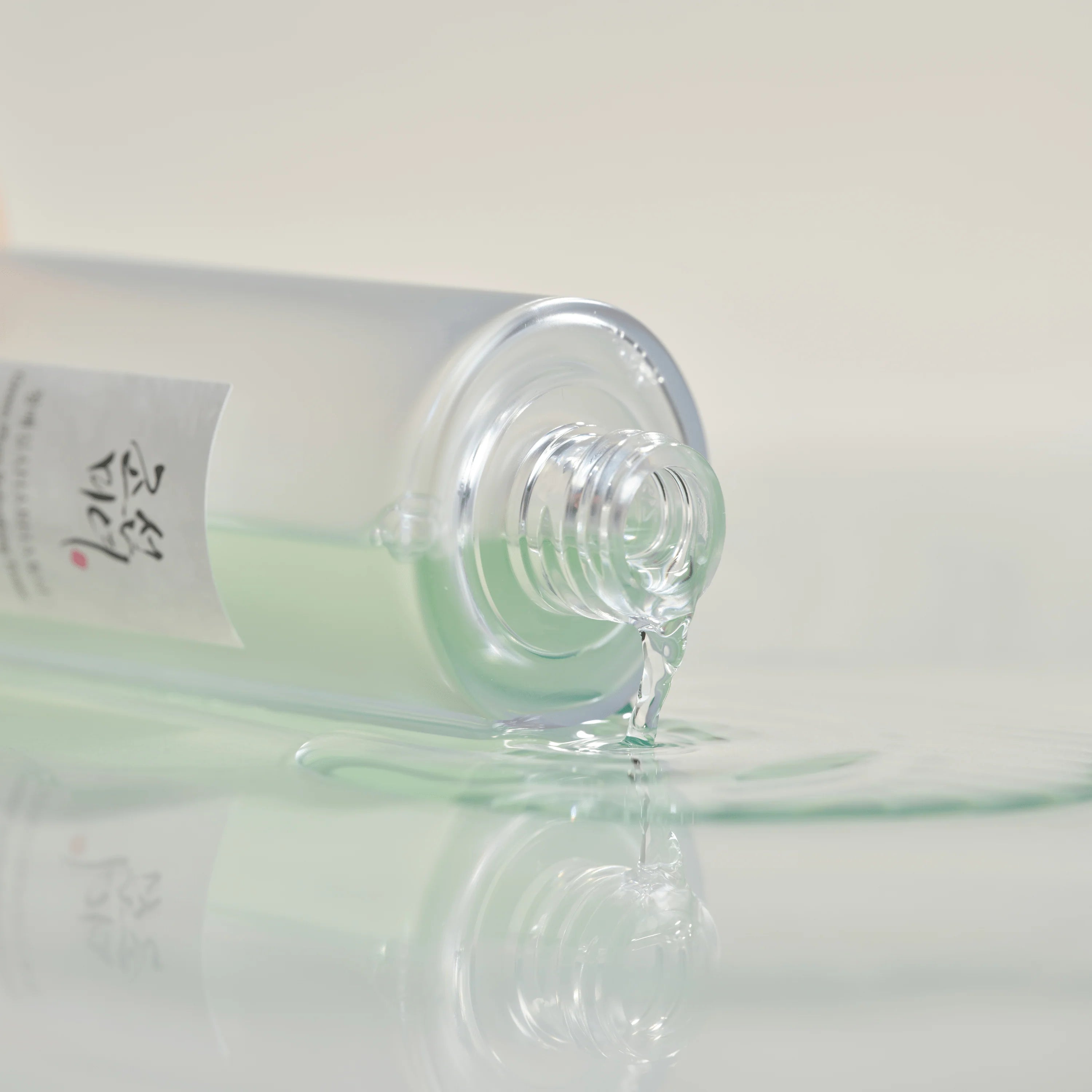 Alcohol bottle with a droplet on a white background