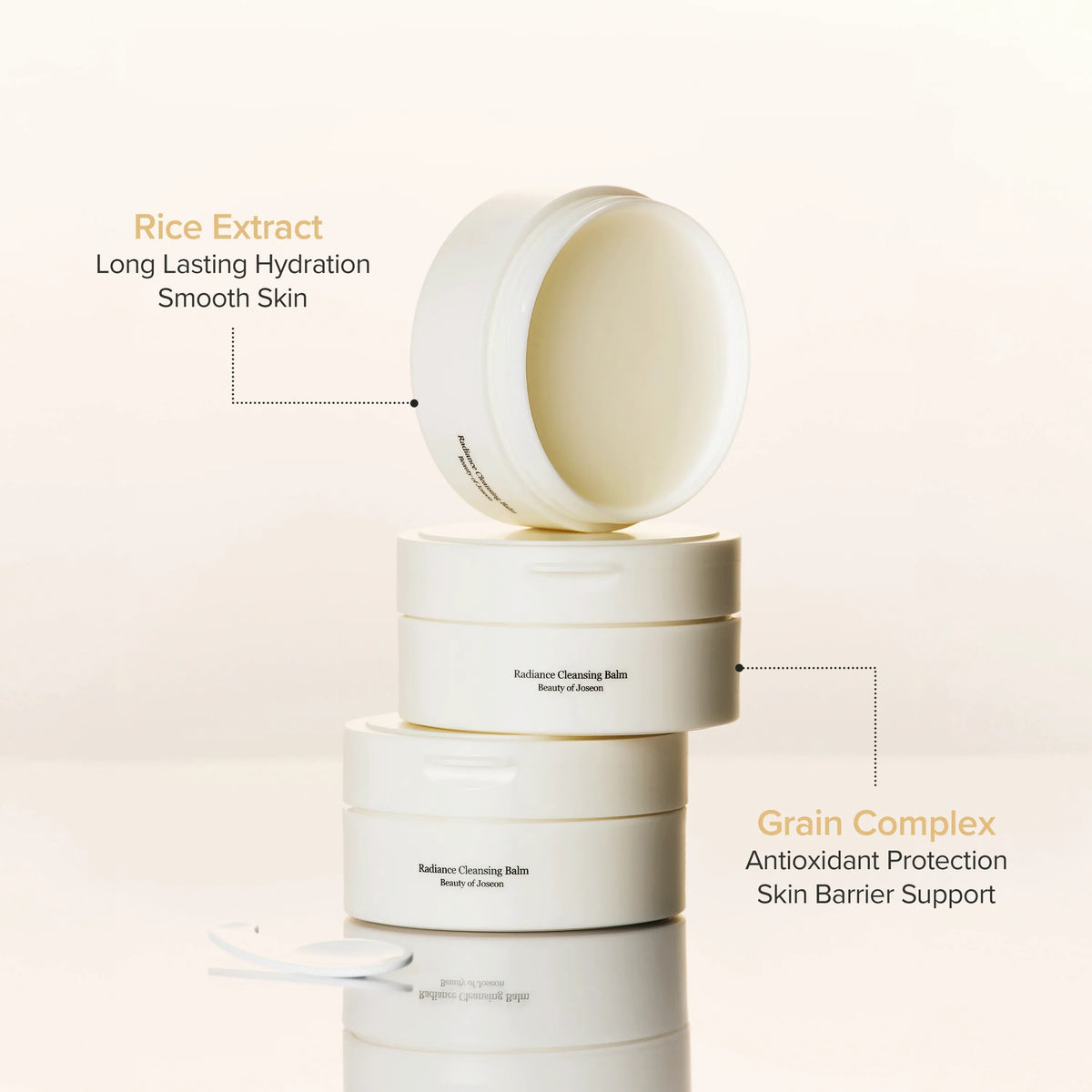 Stack of white skincare containers with text highlighting rice extract and grain complex benefits on a beige background