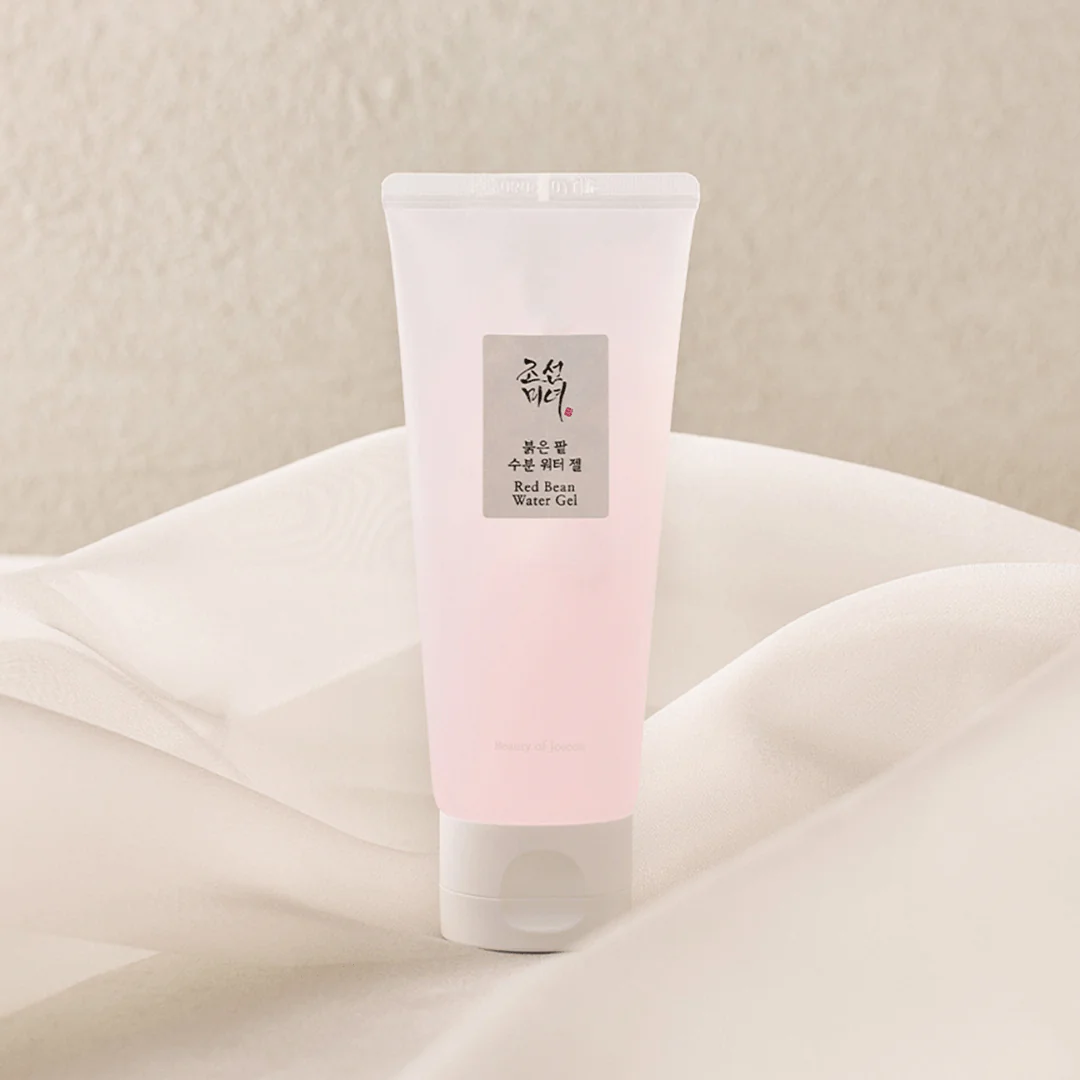 Pink tube of skincare product on a soft beige background