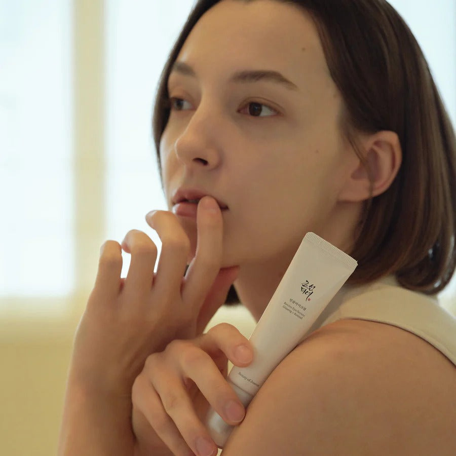 Woman holding a skincare product with a blurred background