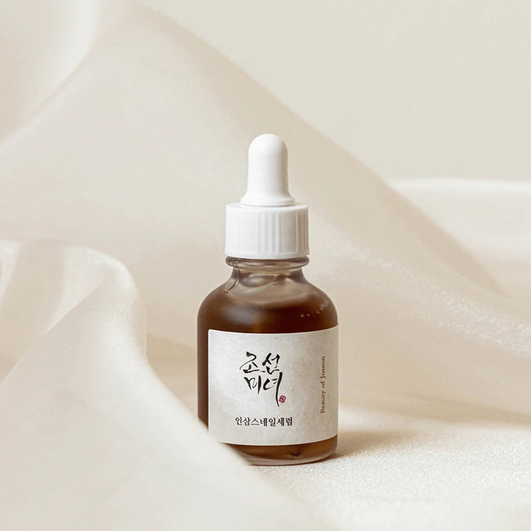 Bottle of skincare serum with dropper on a soft beige background