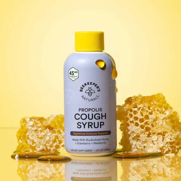 Bottle of propolis cough syrup with honeycomb on a yellow background