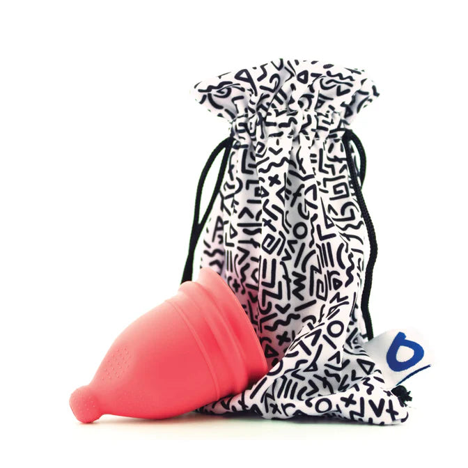 Pink menstrual cup with a patterned drawstring bag on a white background