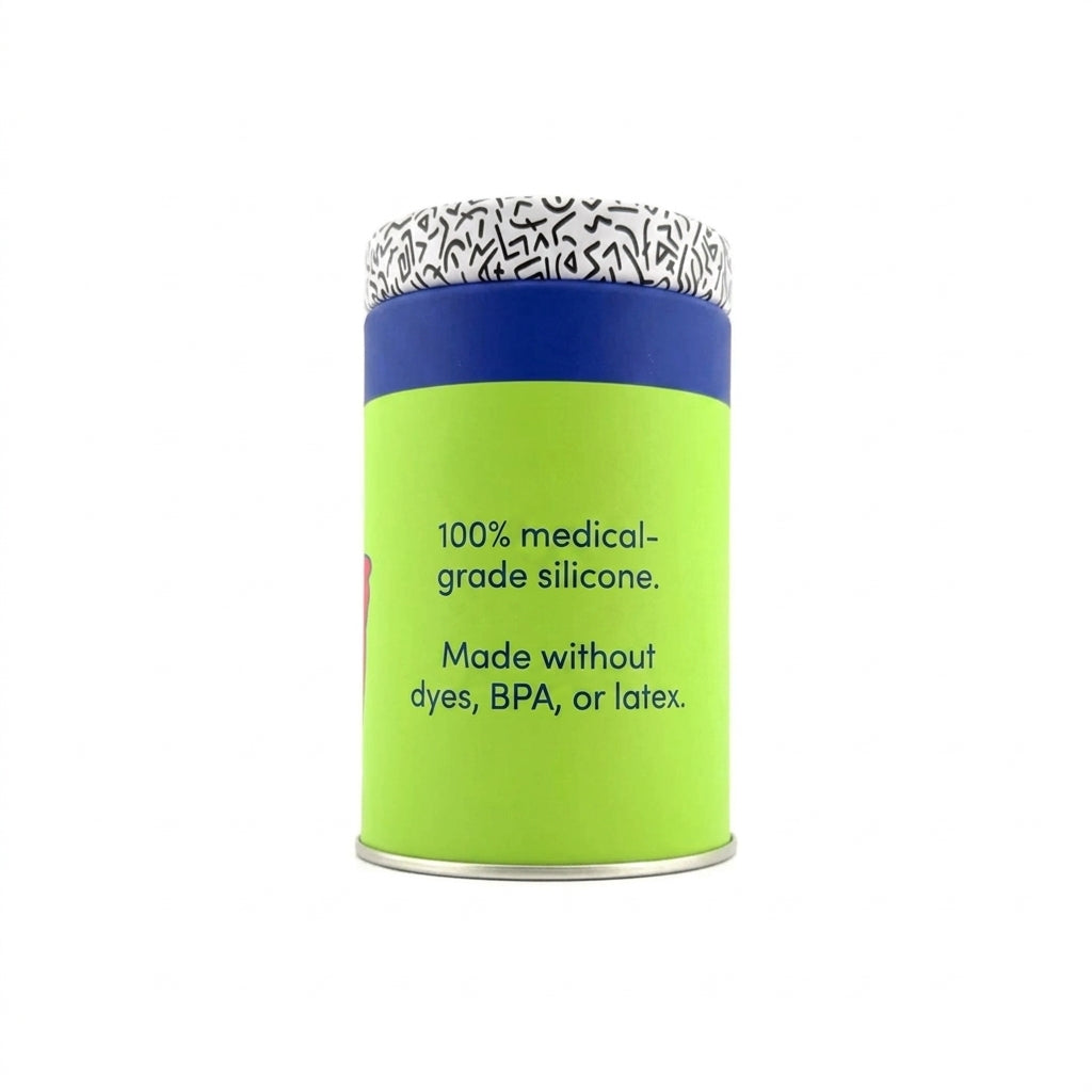 A cylindrical container of medical-grade silicone, featuring a bright lime green body with black text, a dark blue band, and a patterned white lid with black markings.