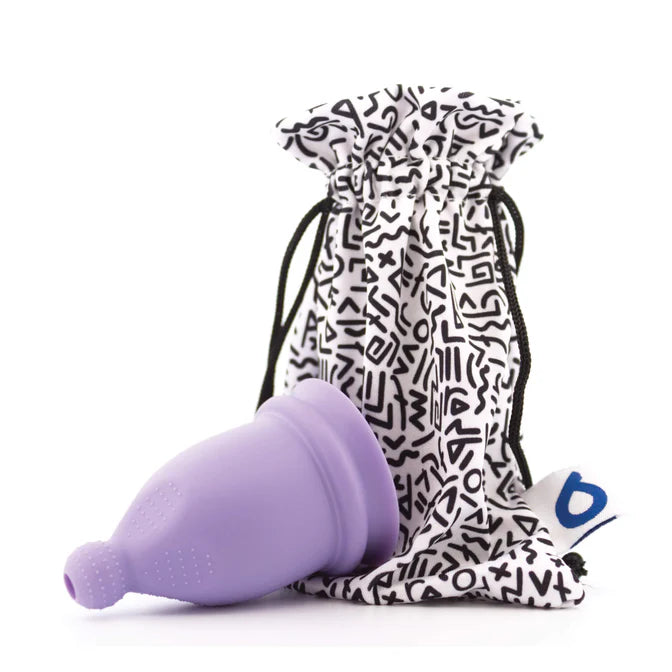 Purple menstrual cup with a patterned drawstring bag on a white background