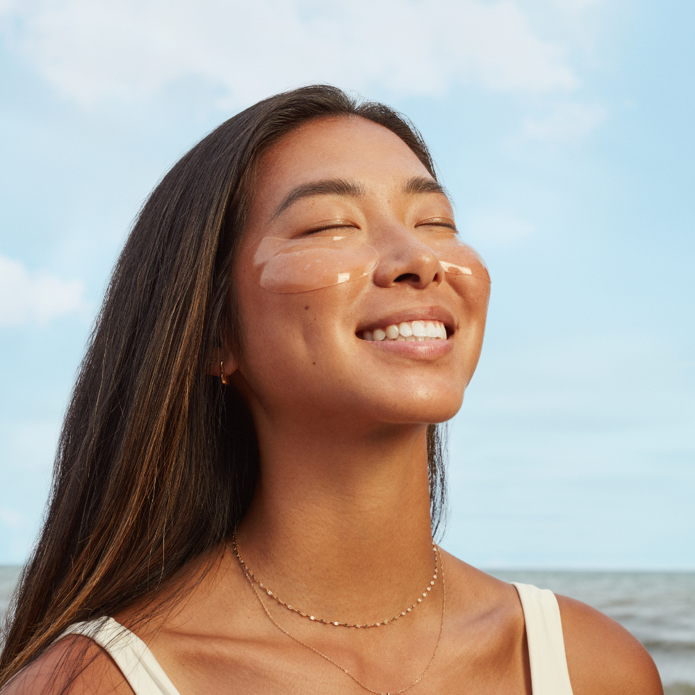 Woman with sun-kissed skin against a clear blue sky