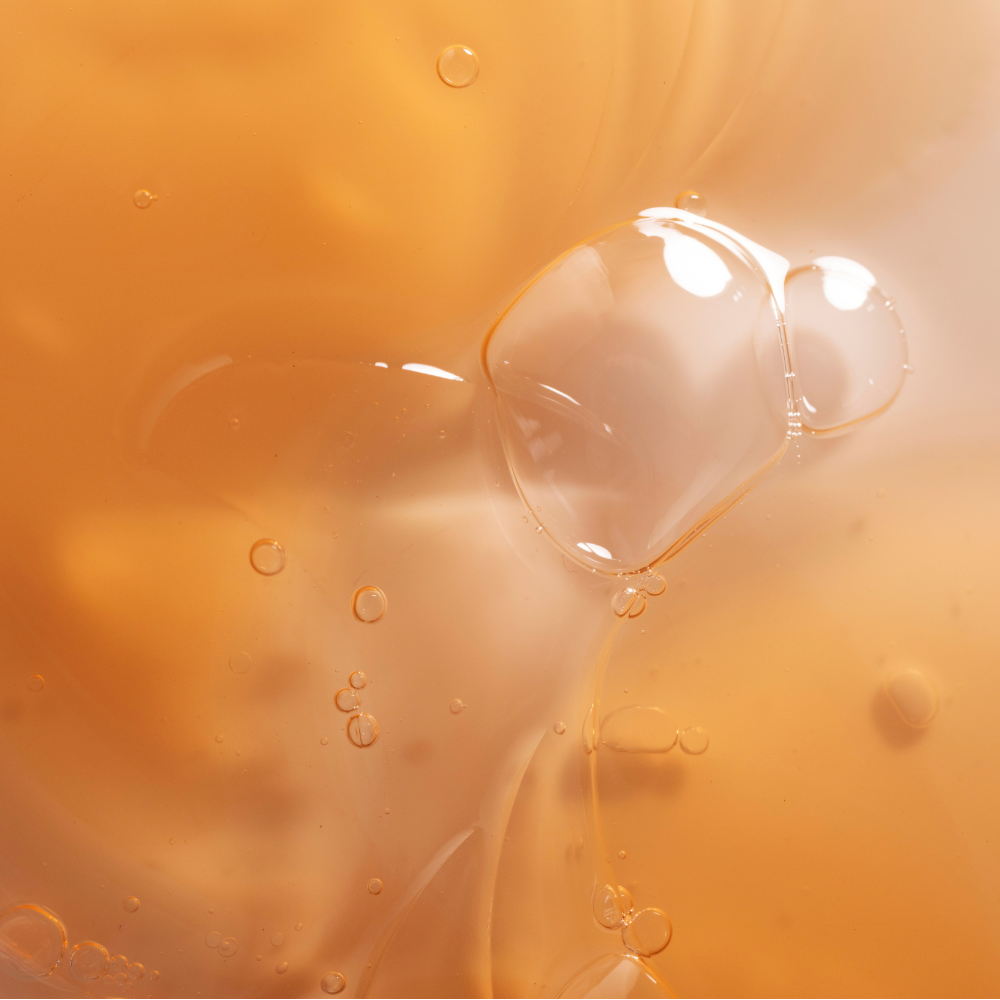 Close-up of a clear gel-like substance with bubbles on a beige background