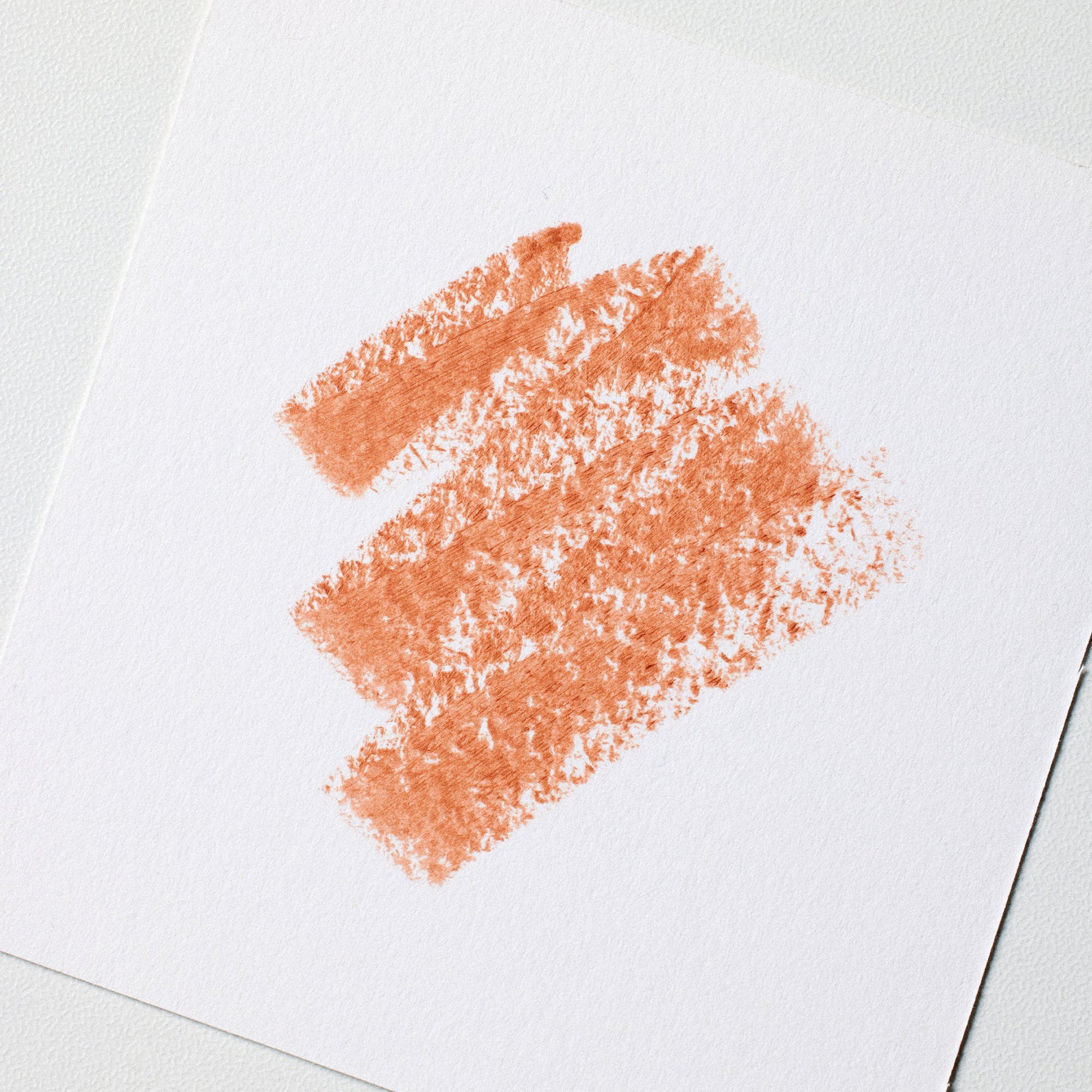 Coral-colored lipstick smear on a white background