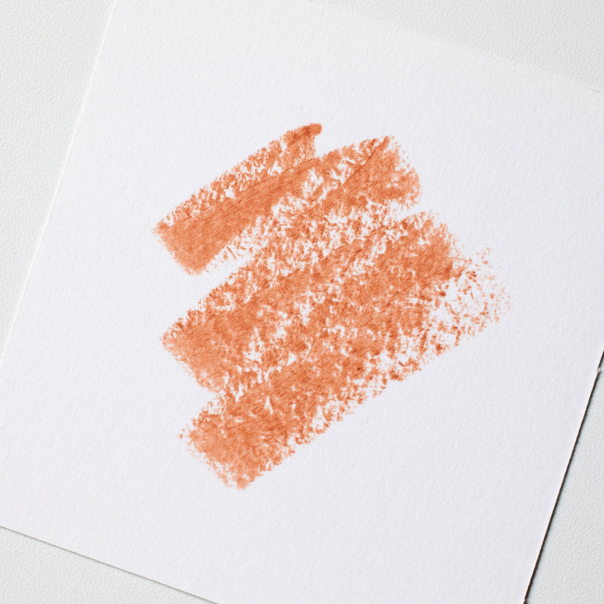 Coral-colored lipstick smear on a white background