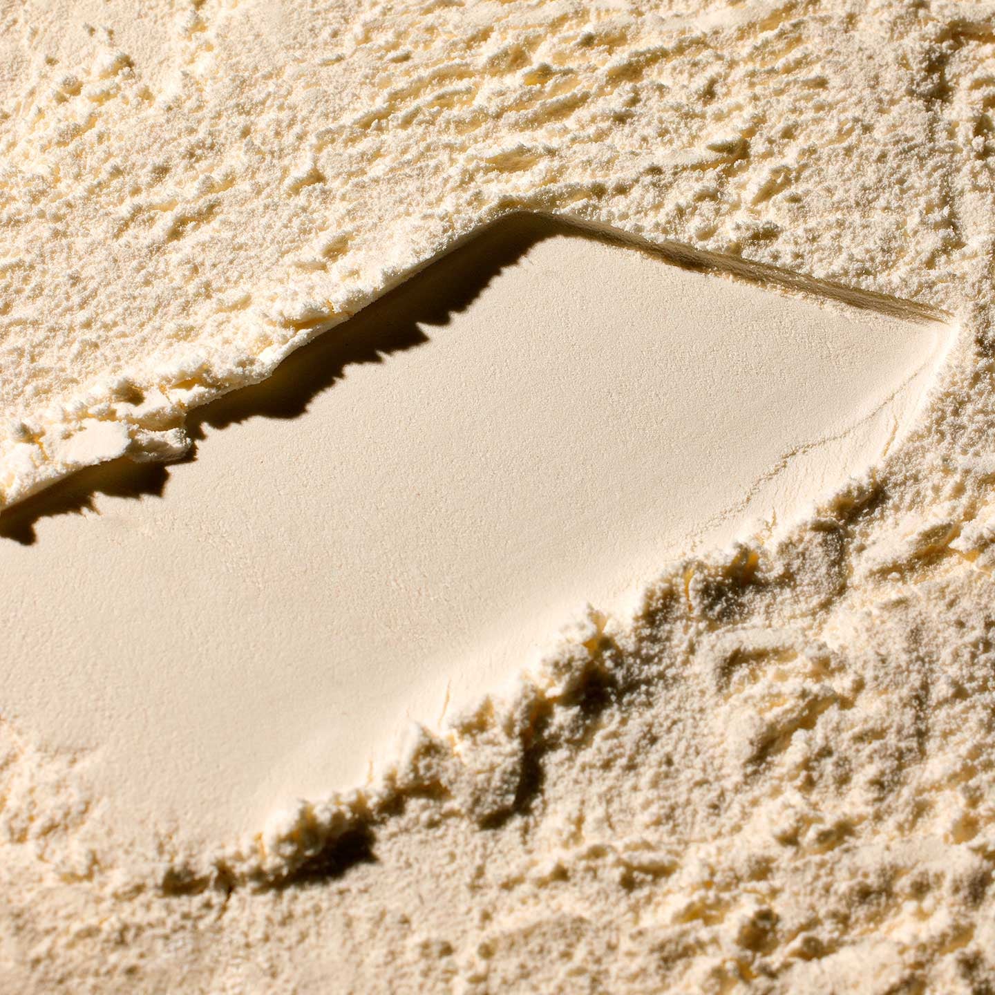 Close-up of a textured beige surface with a rectangular depression