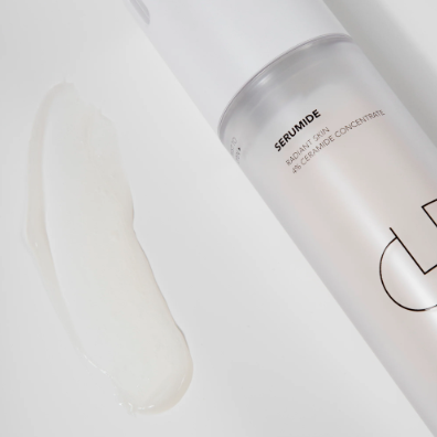 Skincare serum bottle with white cap and visible brand logo on a white background
