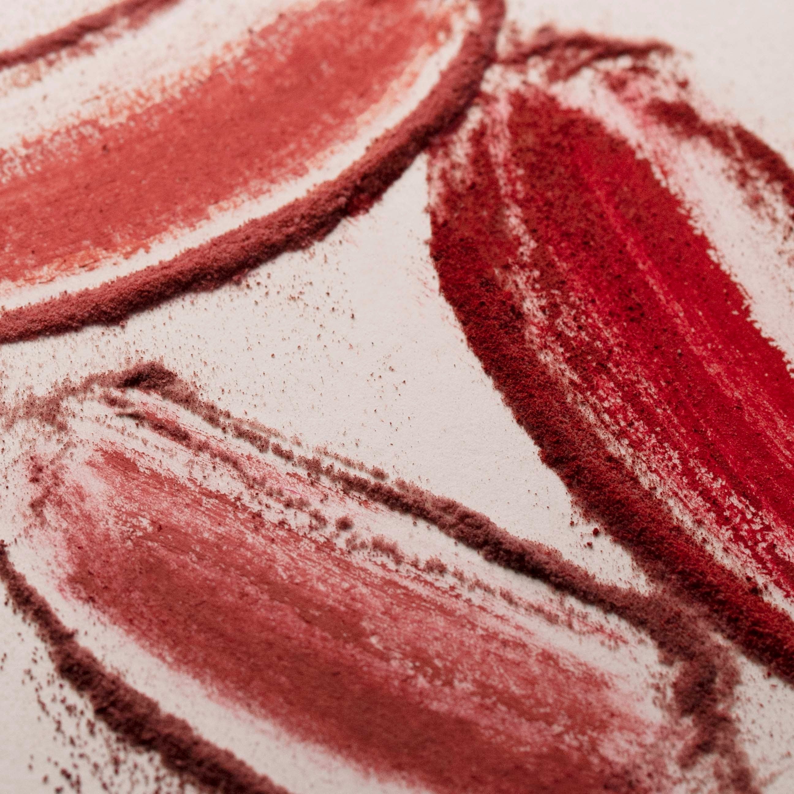Close-up of red lipstick swatches on a white background
