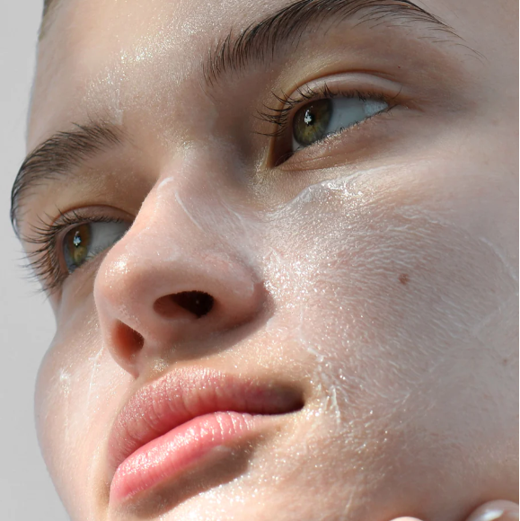 Close-up of a person's face with a neutral expression on a light gray background