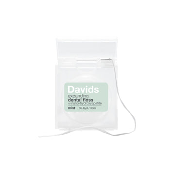 A pack of Davids expanding dental floss in mint flavor, shown in a clear plastic pouch with a white string and a light green label on a white background.