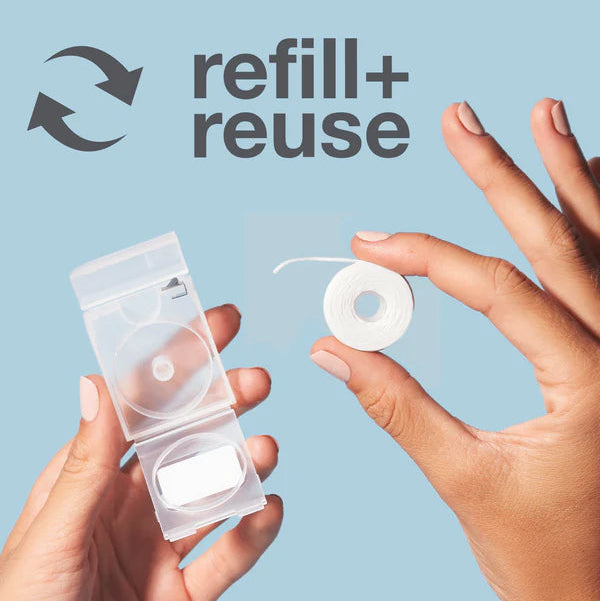 Hands holding a small container with a circular component against a light blue background, featuring the 'refill+ reuse' logo.
