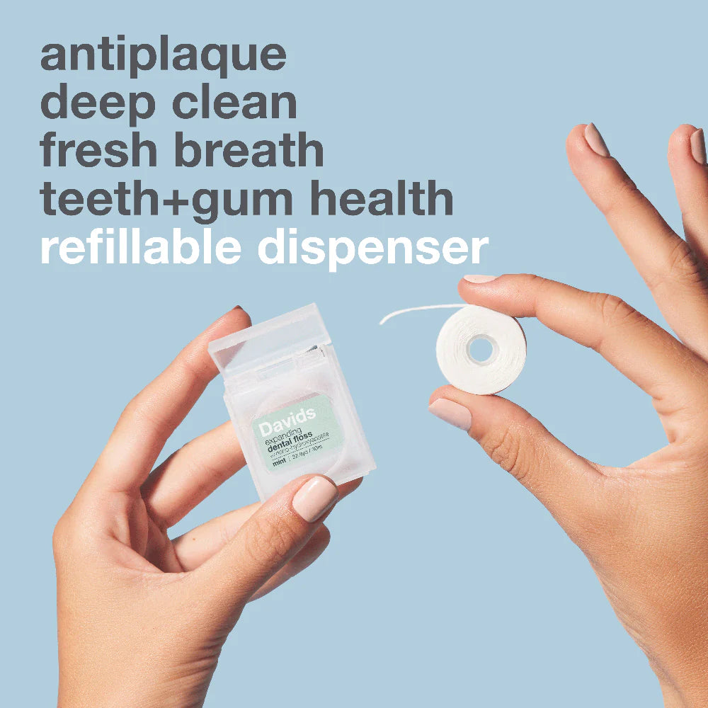 Hands holding a refillable dispenser with text about dental health on a light blue background