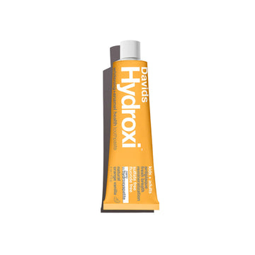 A tube of Davids Hydroxi tooth powder in orange with a white cap, shown on a plain white background.