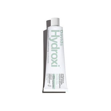 A squeeze tube of Davids Hydroxi toothpaste on a plain white background.