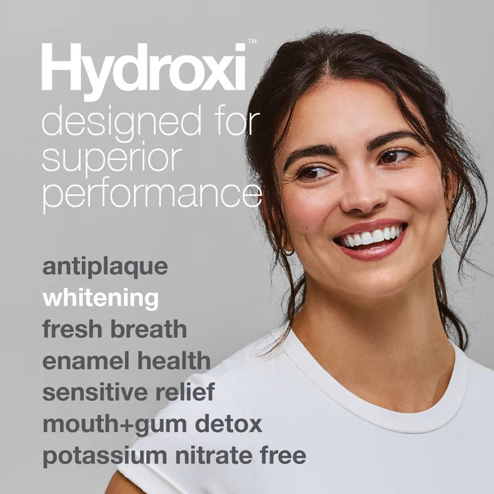 Woman with a smile, featuring Hydroxi product benefits on a gray background