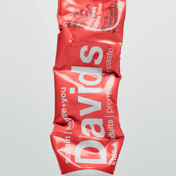 Red tube of David's premium fruit paste on a gray background