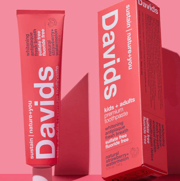Davids toothpaste tube and box on a pink background