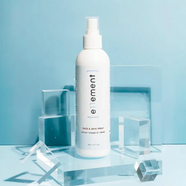 White spray bottle labeled 'e11ement' on a light blue background