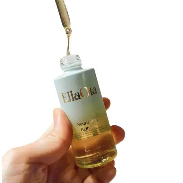 Bottle of EllaOla Nourishing Belly Oil held by a hand with a dropper.