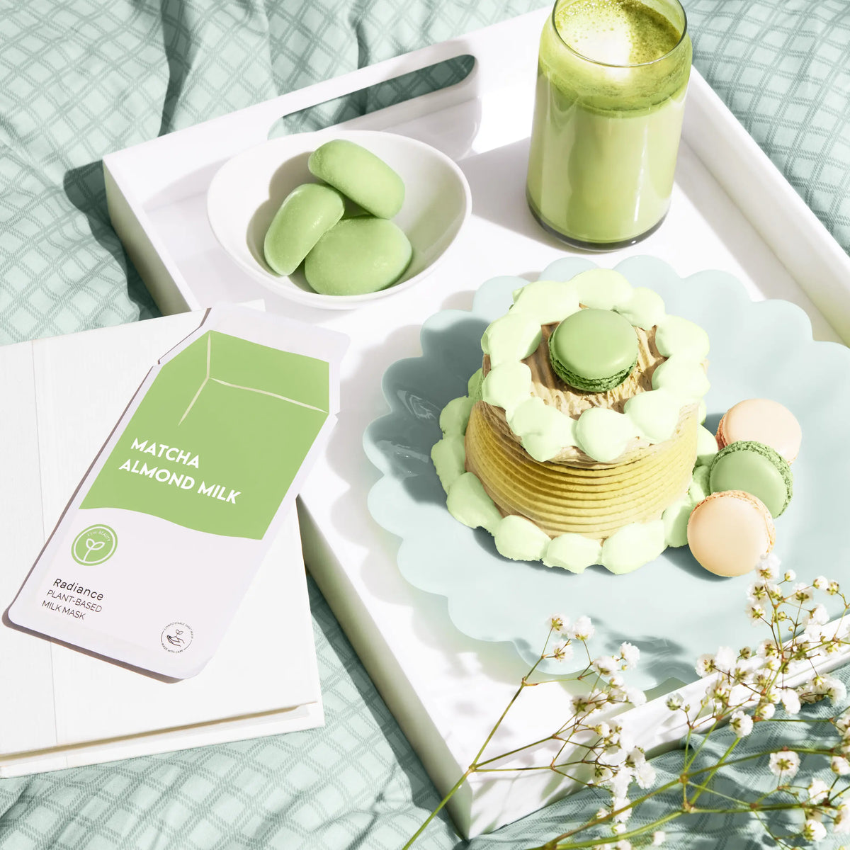 Green-themed dessert and drink set on a tray with a matcha almond milk package.