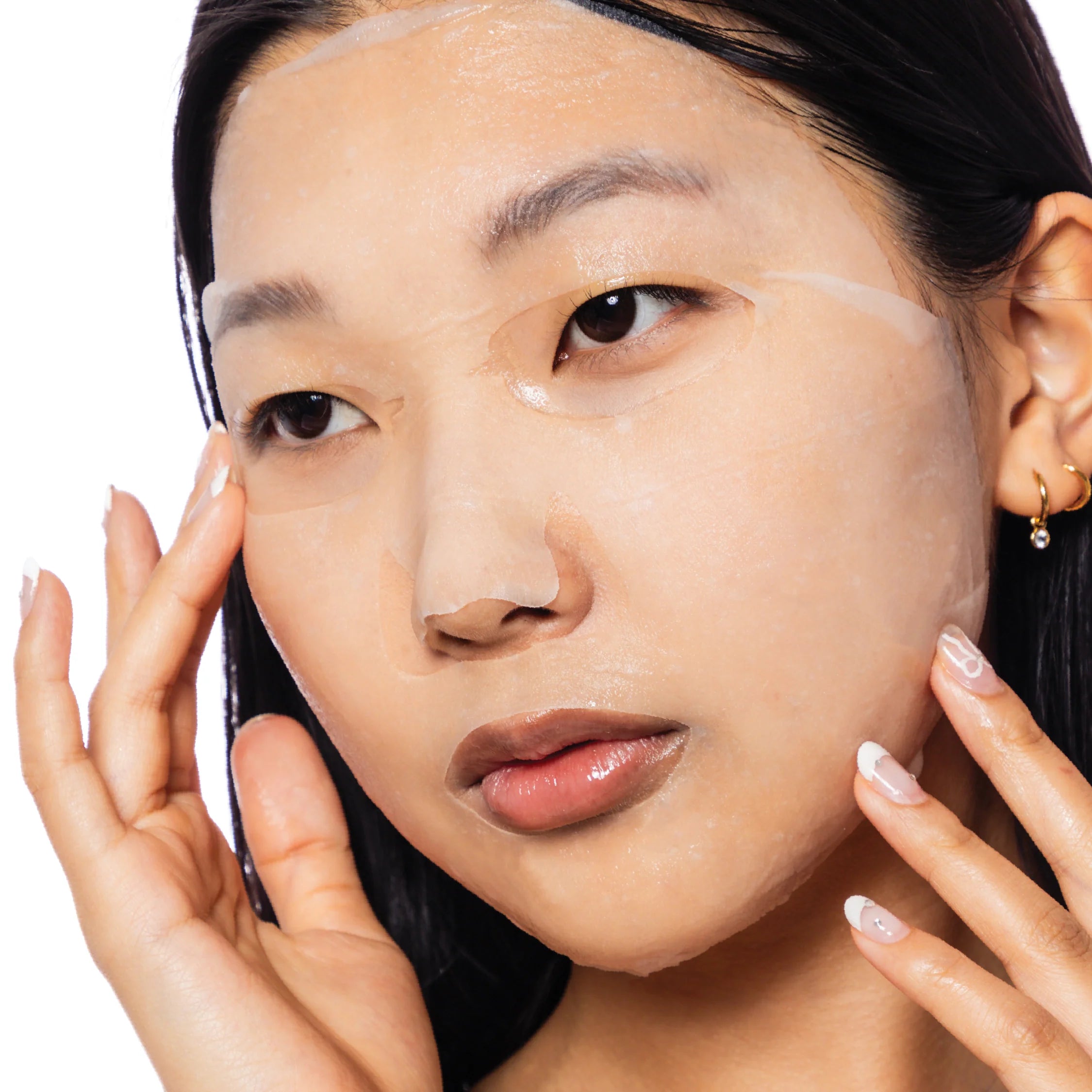 Woman applying a facial mask with a white background