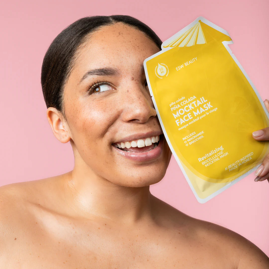 Model holding ESW Beauty Piña Colada Revitalizing Biocellulose Mocktail Mask, showcasing radiant skin results from The Pharmacy Lab.