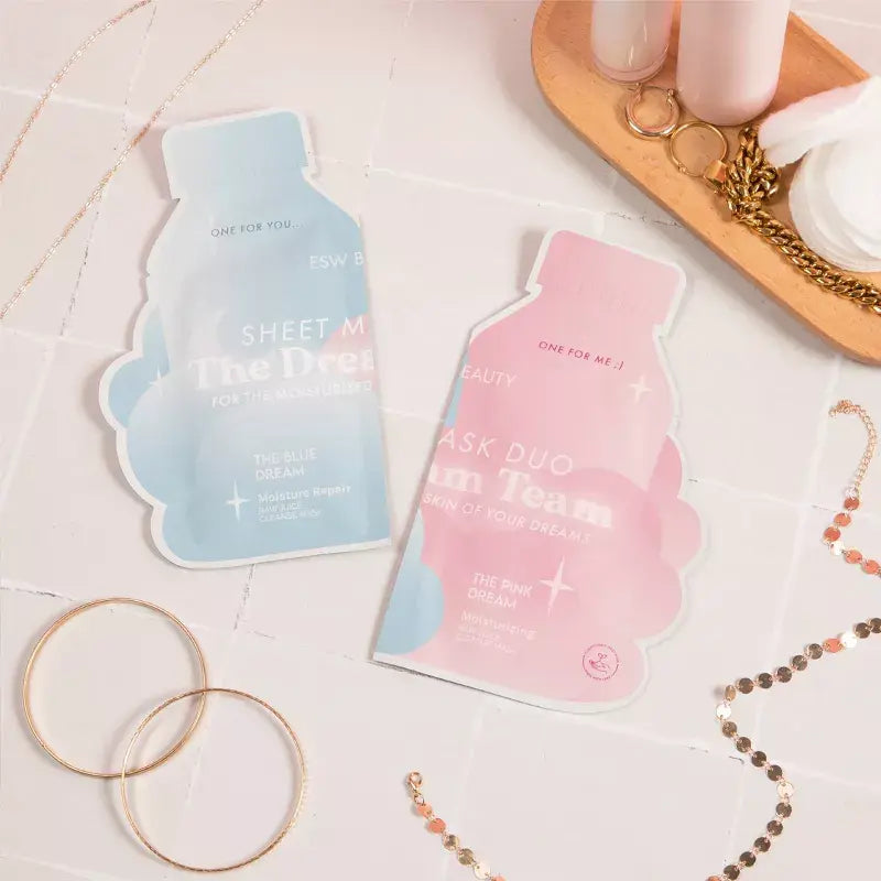 Flat lay of ESW Beauty The Dream Team Sheet Mask Duo from The Pharmacy Lab, styled with jewelry for a self-care night aesthetic.