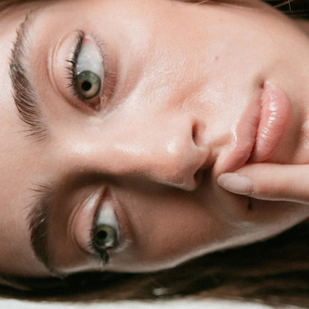Close-up of a woman's face with a neutral expression on a light background