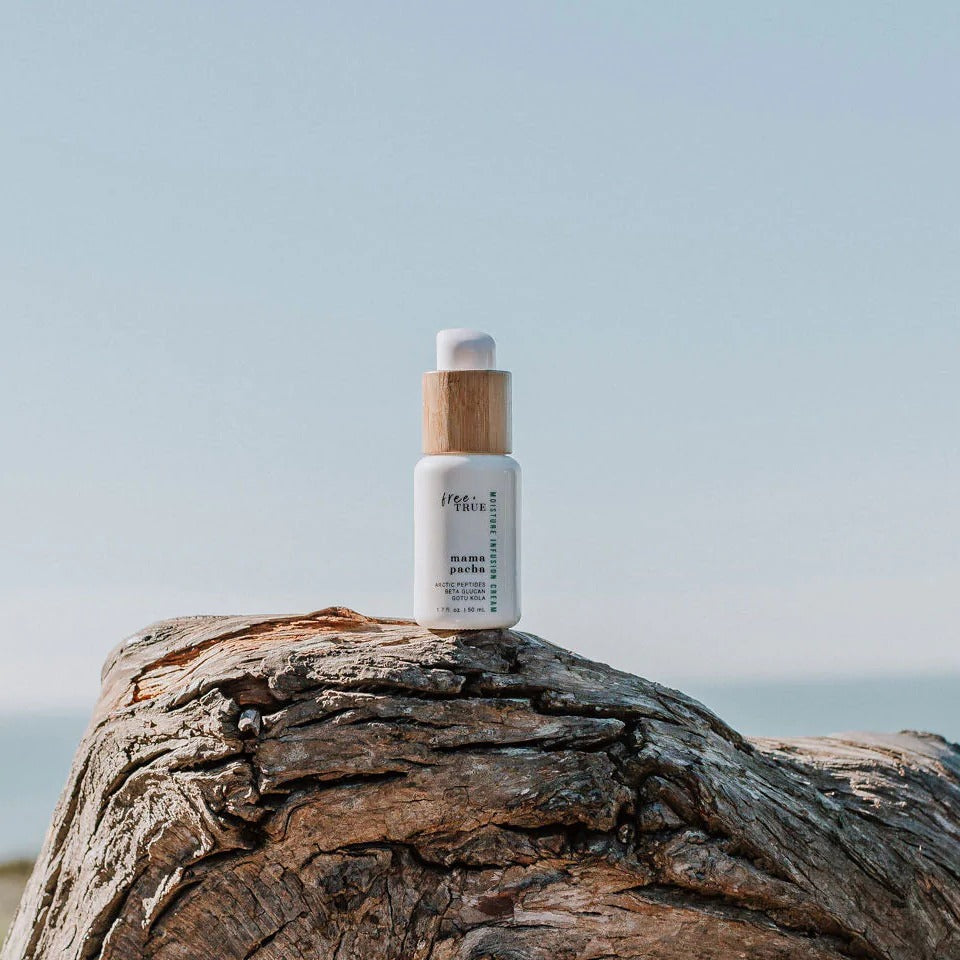 Skincare bottle on a wooden log with a clear sky background