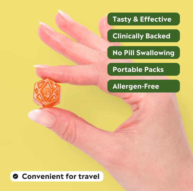 Hand holding a small orange and yellow supplement with text highlighting benefits on a yellow background
