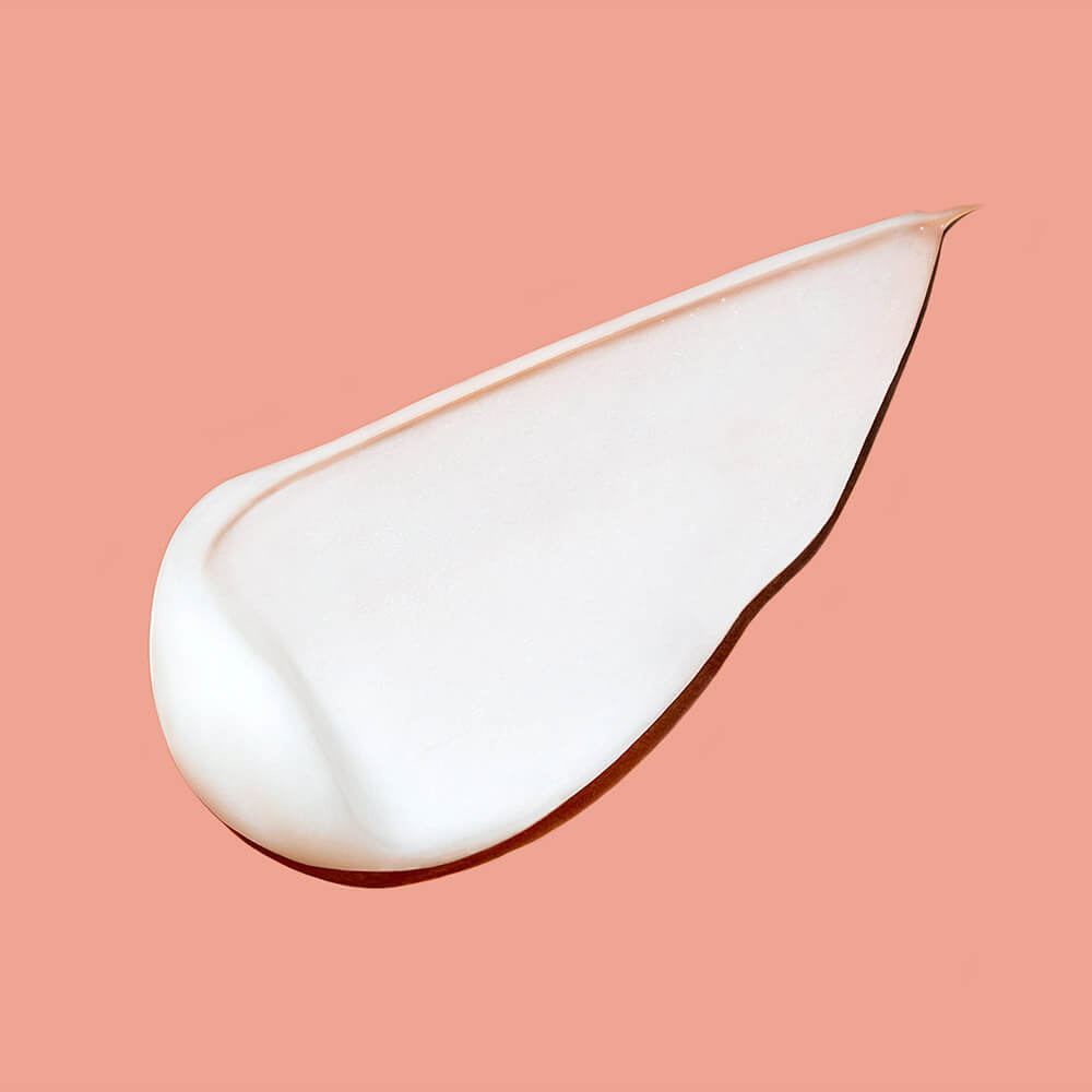 White cream droplet on a pink background