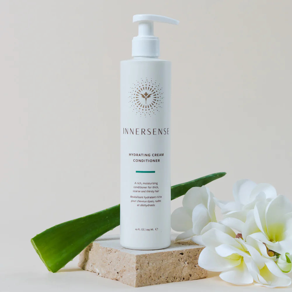 Inversense hydrating cream conditioner bottle with aloe vera leaf and white flowers on a light background