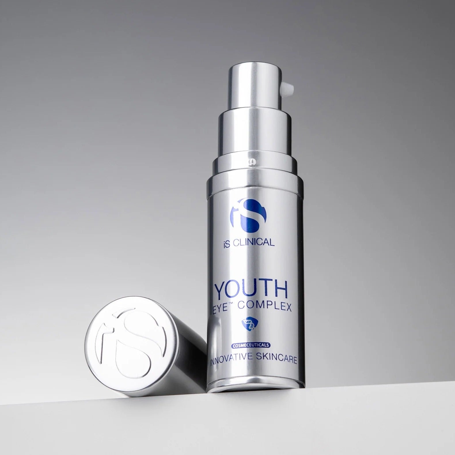 Silver skincare bottle labeled 'Youth Eye Complex' on a gray background