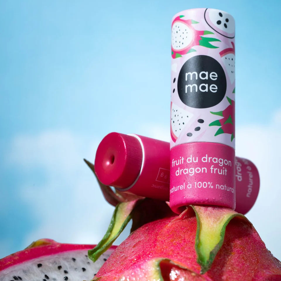 Two lip balm tubes on a dragon fruit with a blue sky background