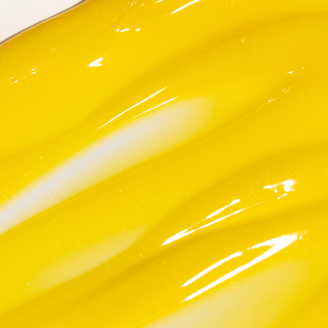 Yellow lip oil tube with 'mae mae' branding on a white background